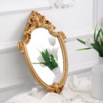 Superbe miroir doré ancien dans un déco épuré près d'une plante