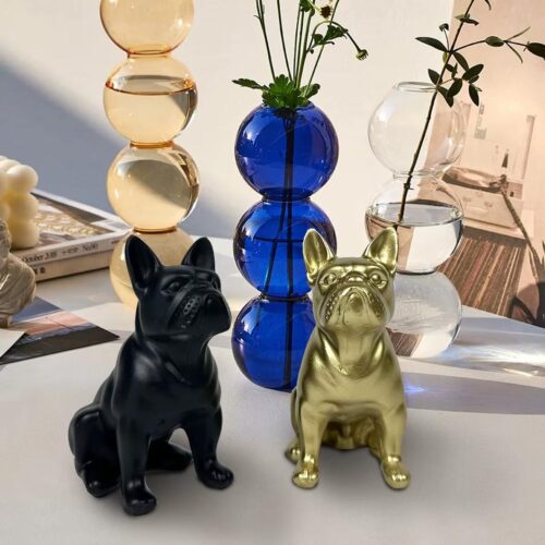 Statuettes bouledogue français noir et doré devant vase bleu