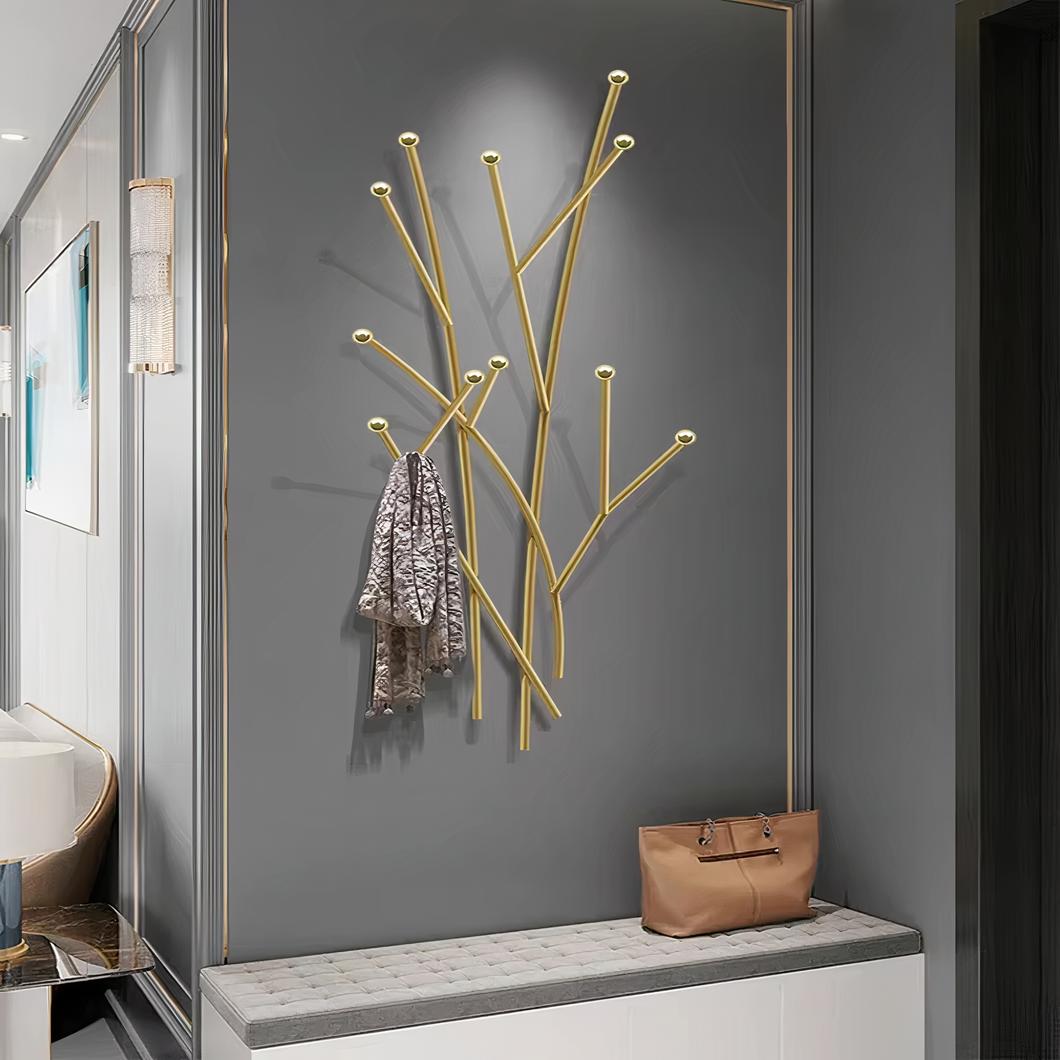 Arbre mural porte-manteau doré accroché au mur gris.