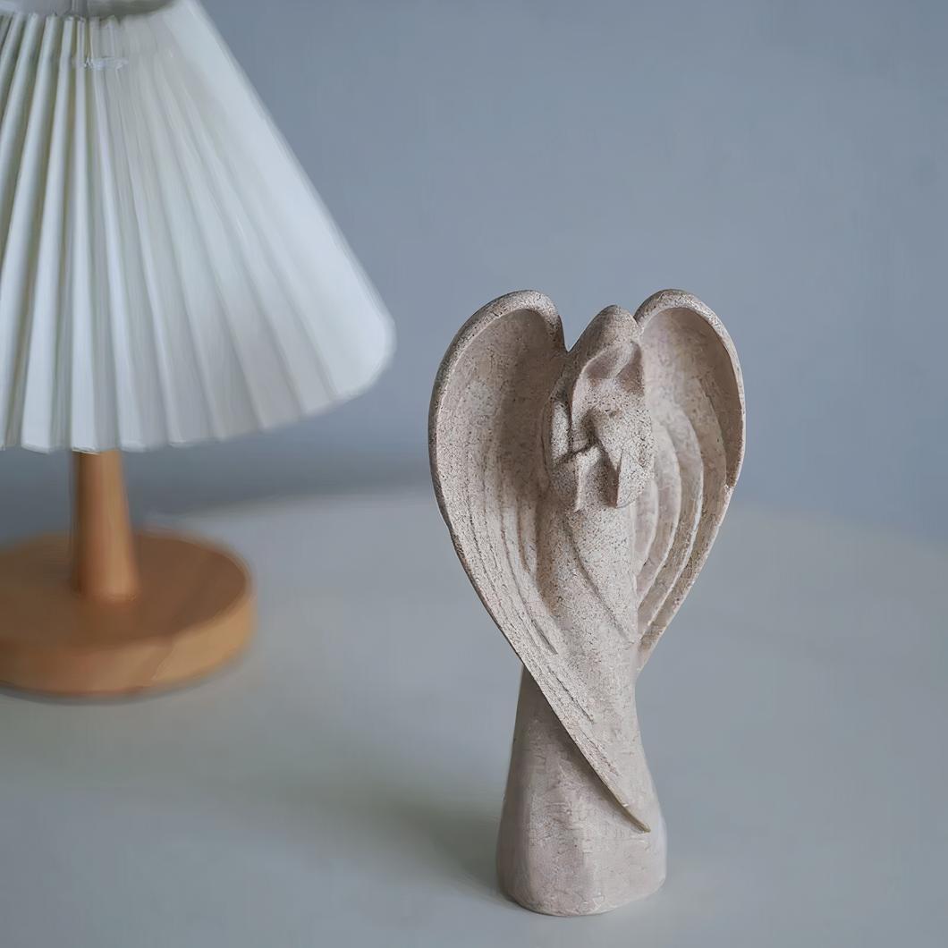statuette ange en résine beige devant lampe