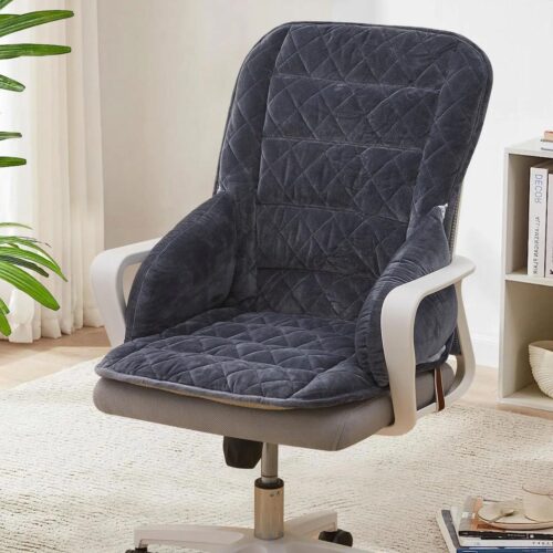 Photo d'un coussin gris foncé en velours placé sur une chaise de bureau beige à accoudoirs dans une pièce claire