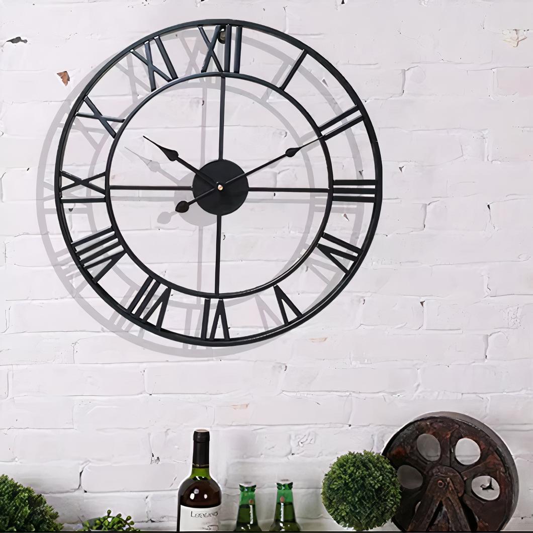 Horloge murale industrielle chiffres romains sur un mur blanc au dessus d'une commode avec une bouteille de vin et des objets vintage.