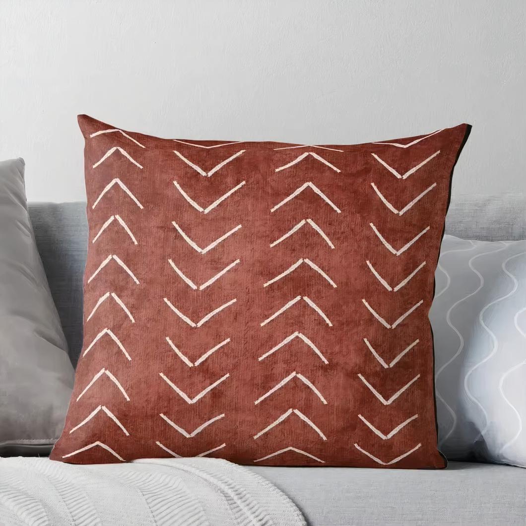 hhoto d'un coussin carré à housse terracotta à chevrons beige sur un canapé gris beige