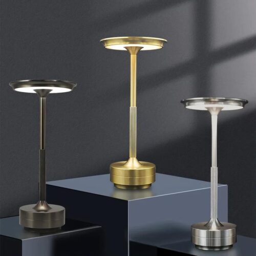 Photo de trois lampes sans fil allumées posées sur des socles gris de différentes hauteurs sur un fond gris-noir