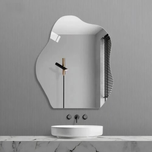 On voit une vasque et un miroir asymétrique adhésif en forme de nuage au dessus, sur un mur gris.