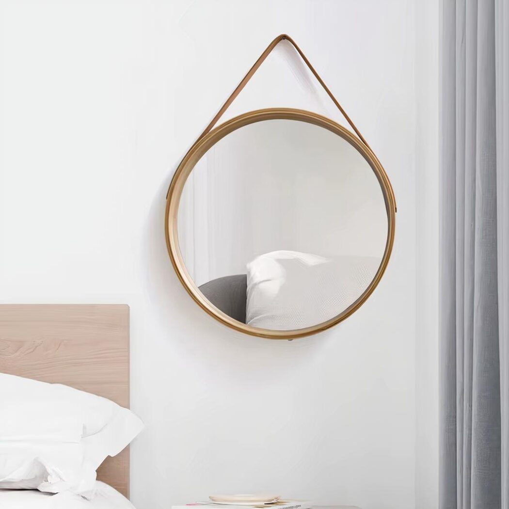 Miroir rond bois avec lanière en cuir, près d'un lit