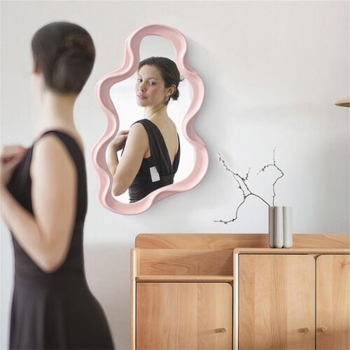 Femme brune qui se regarde dans un miroir vague rose