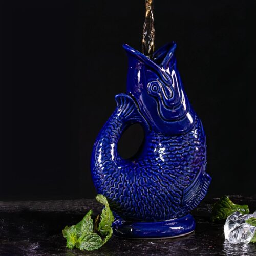 Vase poisson bleu sur fond noir.