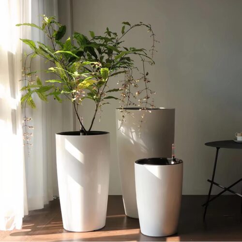 Pots de fleur XXL rond à côté d'une fenêtre.