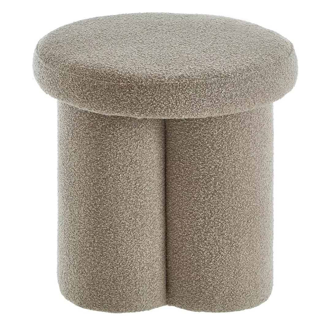 Photo d'un pouf bouclette gris circulaire à trois pieds collés sur un fond blanc