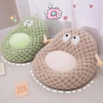 Photo de deux pouf pour enfants représentant grssièrement un bonhomme avec de petits bras et de gros yeux l'un beige et l'autre vert