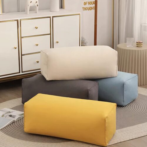 Photo représentant quatre poufs rectangulaire en velours de couleurs différentes posés dans un salon sur un tapis beige