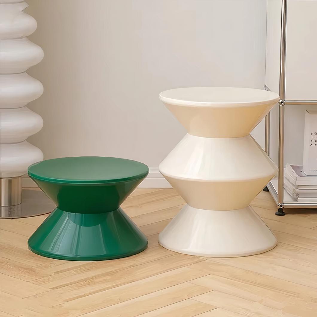 Photo de deux poufs tabouret l'un vert petite taille et l'autre blanc plus grand devant un lampadaire moderne blanc et sur un sol en parquet clair
