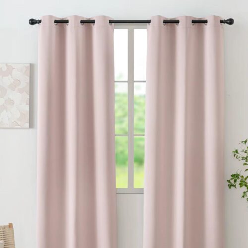 Rideau rose devant une fenêtre accroché à une tringle.