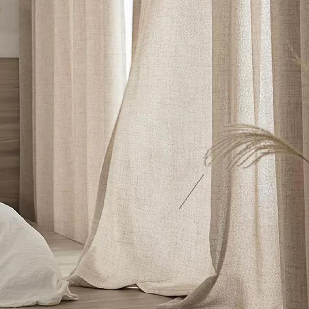 Rideau beige devant une fenêtre.