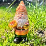 Nain de jardin jaune avec pot de miel et abeilles dans l'herbe