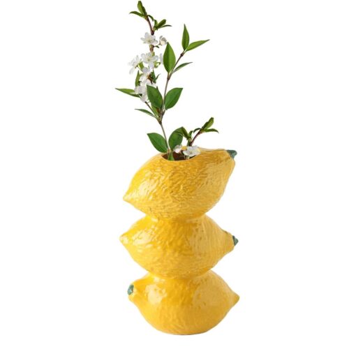 Vase avec trois citrons sur fond blanc.