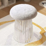 Photo d'un pouf tabouret pied en plastique design et assise en bouclette gris posé sur un tapis blanc et jaune dans un salon