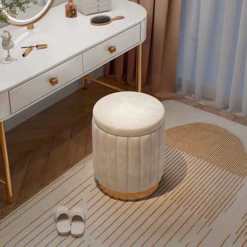 Photo d'un pouf tabouret en velours blanc à base dorée devant une coiffeuse blanche sur un tapis beige